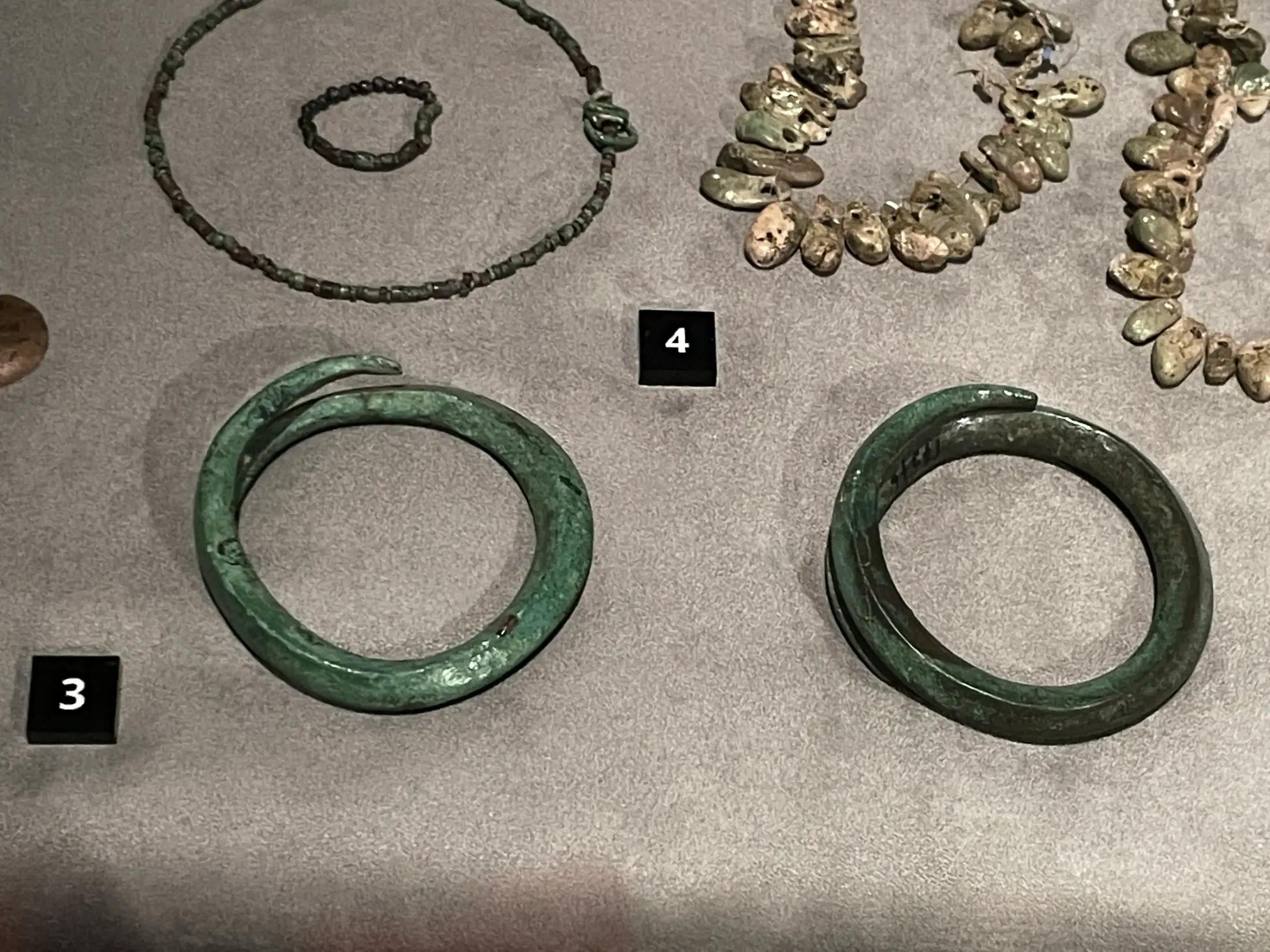 Copper bracelets and necklaces in raking light